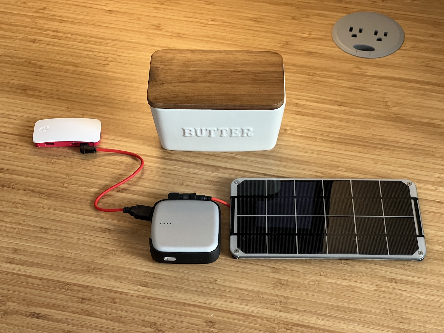 Uma Butter Box: Um Raspberry Pi Zero W 2 ligado a uma pilha e a um painel solar.